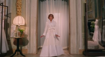 Movie still from “Book Club: The Next Chapter” (2023), directed by Bill Holderman – A woman in a white dress standing in front of a window; Wide shot, Over the shoulder angle