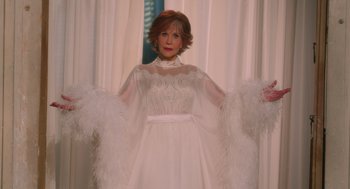 Movie still from “Book Club: The Next Chapter” (2023), directed by Bill Holderman – An older woman in a white dress with feathers; Medium shot, Over the shoulder angle