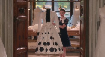 Movie still from “Book Club: The Next Chapter” (2023), directed by Bill Holderman – A woman standing next to a dress on display in a store; Wide shot, High angle