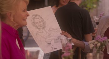 Movie still from “Book Club: The Next Chapter” (2023), directed by Bill Holderman – A person holding a drawing of a woman; Close Up shot, Over the shoulder angle