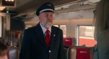 Movie still from “Book Club: The Next Chapter” (2023), directed by Bill Holderman – A man in a uniform standing on a train; Medium shot, Over the shoulder angle