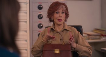 Movie still from “Book Club: The Next Chapter” (2023), directed by Bill Holderman – An older woman holding a brown purse in a room; Medium shot, Over the shoulder angle