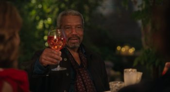 Movie still from “Book Club: The Next Chapter” (2023), directed by Bill Holderman – An older man holding up a glass of wine; Medium shot, Over the shoulder angle