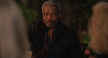 Movie still from “Book Club: The Next Chapter” (2023), directed by Bill Holderman – A man sitting in a chair wearing a brown jacket; Close Up shot, Over the shoulder angle