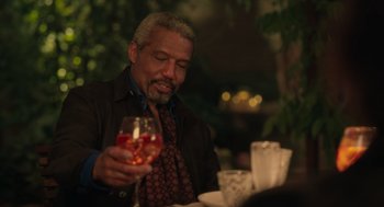 Movie still from “Book Club: The Next Chapter” (2023), directed by Bill Holderman – A man sitting at a table with a glass of wine; Medium shot, Over the shoulder angle