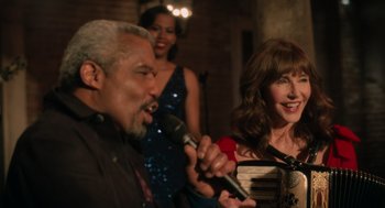 Movie still from “Book Club: The Next Chapter” (2023), directed by Bill Holderman – A man and a woman sing into microphones; Medium shot, Over the shoulder angle