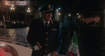 Movie still from “Book Club: The Next Chapter” (2023), directed by Bill Holderman – A man in a military uniform standing next to a boat; Medium shot, Over the shoulder angle