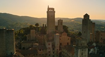 Movie still from “Book Club: The Next Chapter” (2023), directed by Bill Holderman – The sun is setting over a town with a clock tower; Extreme Wide shot, High angle
