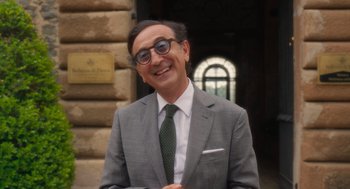 Movie still from “Book Club: The Next Chapter” (2023), directed by Bill Holderman – A man in a suit and tie smiling for the camera; Medium shot, Over the shoulder angle