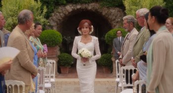 Movie still from “Book Club: The Next Chapter” (2023), directed by Bill Holderman – A woman in a white dress holding a bouquet of white flowers; Wide shot, Over the shoulder angle