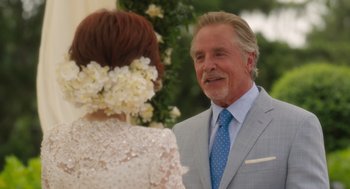 Movie still from “Book Club: The Next Chapter” (2023), directed by Bill Holderman – A man in a gray suit and a woman in a white dress; Close Up shot, Over the shoulder angle