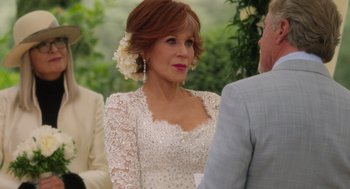 Movie still from “Book Club: The Next Chapter” (2023), directed by Bill Holderman – An older woman wearing a white dress and a flower in her hair; Close Up shot, Over the shoulder angle