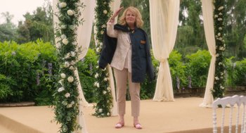 Movie still from “Book Club: The Next Chapter” (2023), directed by Bill Holderman – A woman standing in front of a flower covered arch; Wide shot, Over the shoulder angle