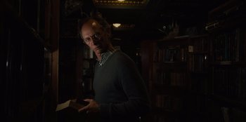 Movie still from “Books of Blood” (2020), directed by Brannon Braga – A man standing in front of a book shelf; Medium shot, Low angle