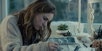 Movie still from “Books of Blood” (2020), directed by Brannon Braga – A girl is looking down at a notebook; Close Up shot, Over the shoulder angle