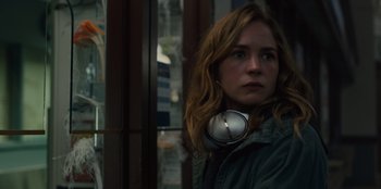 Movie still from “Books of Blood” (2020), directed by Brannon Braga – A woman wearing headphones standing in front of a window; Close Up shot, Over the shoulder angle