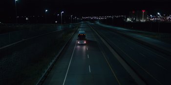 Movie still from “Books of Blood” (2020), directed by Brannon Braga – A bus driving down a street at night; Extreme Wide shot, High angle