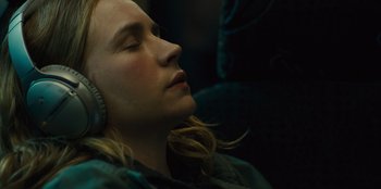 Movie still from “Books of Blood” (2020), directed by Brannon Braga – A woman with her eyes closed listening to headphones; Close Up shot, High angle