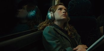 Movie still from “Books of Blood” (2020), directed by Brannon Braga – A woman with headphones sitting on a bus; Close Up shot, High angle