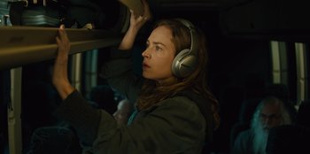 Movie still from “Books of Blood” (2020), directed by Brannon Braga – A woman wearing headphones while standing next to a car; Close Up shot, Low angle