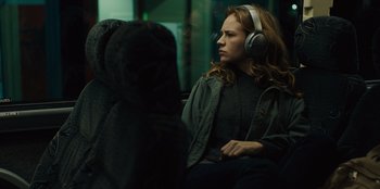 Movie still from “Books of Blood” (2020), directed by Brannon Braga – A woman with headphones sitting on a bus; Medium shot, Over the shoulder angle