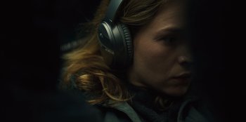 Movie still from “Books of Blood” (2020), directed by Brannon Braga – A woman wearing headphones is sitting in a car; Close Up shot, Over the shoulder angle