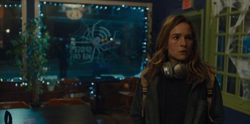 Movie still from “Books of Blood” (2020), directed by Brannon Braga – A woman with headphones standing in a room; Close Up shot, Over the shoulder angle