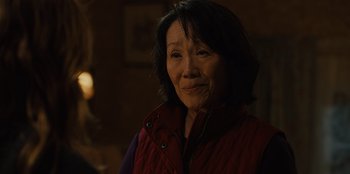 Movie still from “Books of Blood” (2020), directed by Brannon Braga – An older asian woman wearing a red vest; Close Up shot, Over the shoulder angle