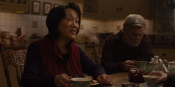 Movie still from “Books of Blood” (2020), directed by Brannon Braga – An older woman sitting at a table with a bowl of food; Medium shot, Over the shoulder angle
