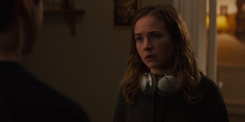 Movie still from “Books of Blood” (2020), directed by Brannon Braga – A woman with headphones around her neck looks at the camera; Close Up shot, Over the shoulder angle