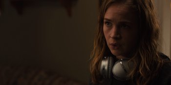 Movie still from “Books of Blood” (2020), directed by Brannon Braga – A woman with headphones in a dark room; Close Up shot, Over the shoulder angle