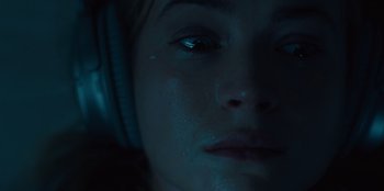 Movie still from “Books of Blood” (2020), directed by Brannon Braga – A person wearing headphones; Close Up shot, Overhead angle