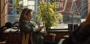 Movie still from “Books of Blood” (2020), directed by Brannon Braga – A woman sitting in a chair with headphones on; Medium shot, Over the shoulder angle