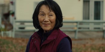 Movie still from “Books of Blood” (2020), directed by Brannon Braga – An older asian woman wearing a red vest; Close Up shot, Over the shoulder angle