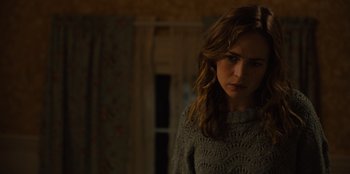 Movie still from “Books of Blood” (2020), directed by Brannon Braga – A woman standing in a dark room looking at the camera; Close Up shot, Over the shoulder angle