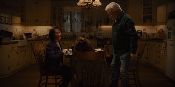 Movie still from “Books of Blood” (2020), directed by Brannon Braga – Two people sitting at a dining room table talking; Wide shot, High angle