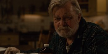 Movie still from “Books of Blood” (2020), directed by Brannon Braga – An older man sitting at a table with a bottle of medicine; Close Up shot, Over the shoulder angle