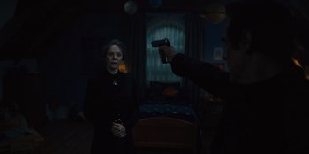 Movie still from “Books of Blood” (2020), directed by Brannon Braga – A man pointing a gun at a woman in a dark room; Medium shot, Over the shoulder angle