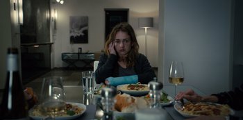 Movie still from “Books of Blood” (2020), directed by Brannon Braga – A woman sitting at a table with plates of food; Medium shot, Over the shoulder angle