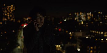 Movie still from “Books of Blood” (2020), directed by Brannon Braga – A young man talking on a cell phone in the dark; Medium shot, Low angle