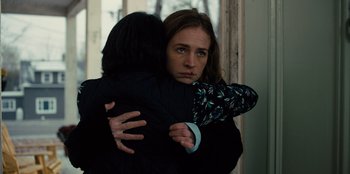 Movie still from “Books of Blood” (2020), directed by Brannon Braga – Two women hugging each other in front of a window; Medium shot, Over the shoulder angle