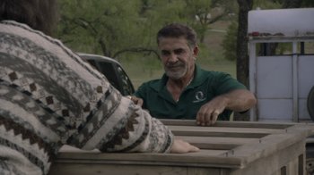 Movie still from “Borat Subsequent Moviefilm” (2020), directed by Jason Woliner – An older man sitting on top of a wooden bench; Medium shot, Over the shoulder angle