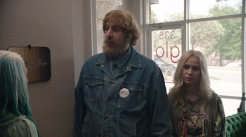 Movie still from “Borat Subsequent Moviefilm” (2020), directed by Jason Woliner – A man with a beard wearing a jean jacket; Medium shot, Over the shoulder angle