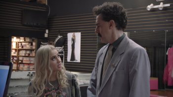 Movie still from “Borat Subsequent Moviefilm” (2020), directed by Jason Woliner – A man and a woman are talking to each other in a store; Medium shot, Over the shoulder angle