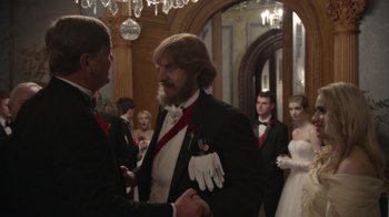 Movie still from “Borat Subsequent Moviefilm” (2020), directed by Jason Woliner – Two men in tuxedos shaking hands at a wedding; Medium shot, Over the shoulder angle