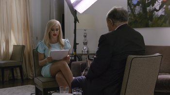 Movie still from “Borat Subsequent Moviefilm” (2020), directed by Jason Woliner – A man and a woman sitting in a room; Medium shot, Over the shoulder angle