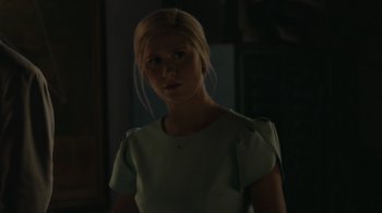 Movie still from “Borat Subsequent Moviefilm” (2020), directed by Jason Woliner – A woman in a white shirt is in a dark room; Close Up shot, Over the shoulder angle