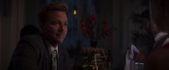 Movie still from “Born a Champion” (2021), directed by Alex Ranarivelo – A person wearing a suit and tie; Close Up shot, Over the shoulder angle