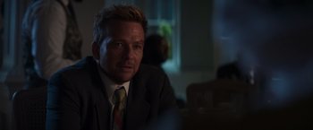 Movie still from “Born a Champion” (2021), directed by Alex Ranarivelo – A person wearing a suit and tie; Close Up shot, Over the shoulder angle