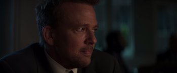 Movie still from “Born a Champion” (2021), directed by Alex Ranarivelo – A person wearing a suit and tie; Close Up shot, Over the shoulder angle